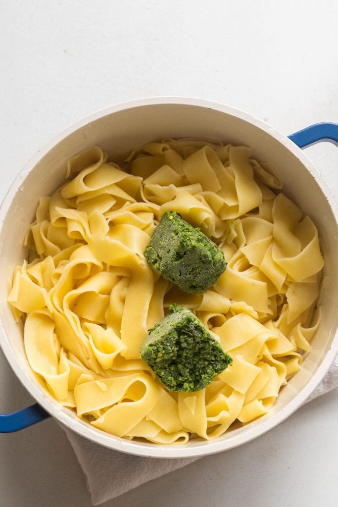 parsley cubes on top of hot pasta in hot
