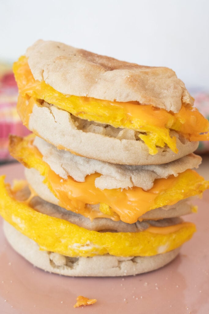 stack of breakfast sandwiches on pink plate.