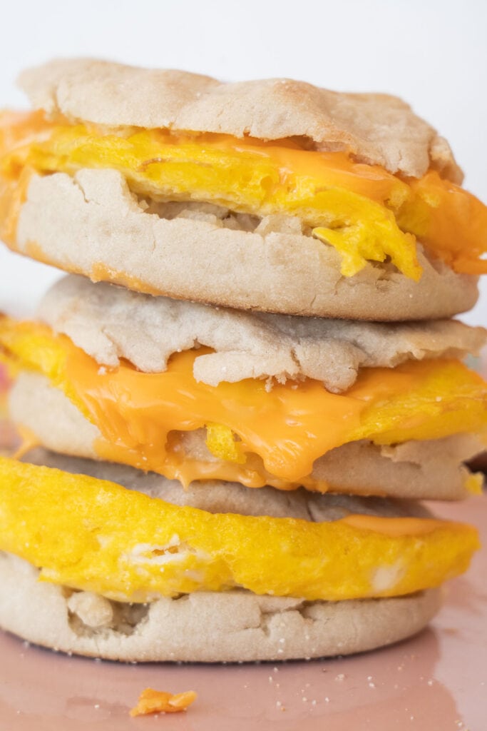 closeup of egg and cheese breakfast sandwiches on english muffins.