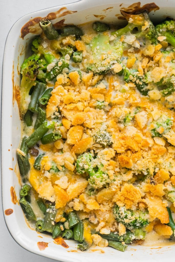 baking dish filled with bubbly cheesy casserole with  broccoli, green beans and ritz crackers.