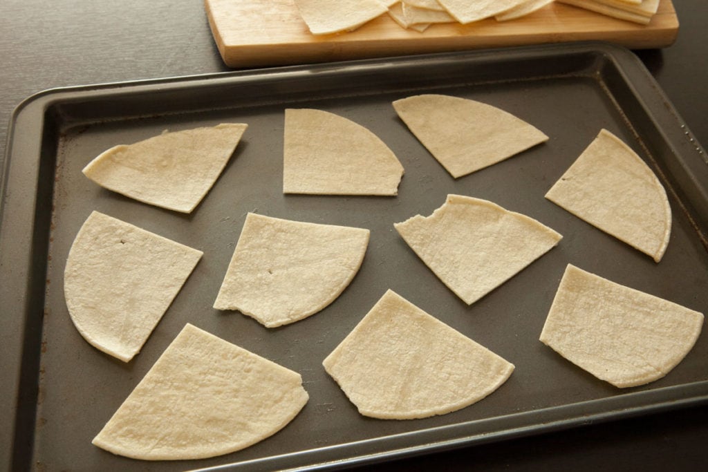 Easy 2 ingredient corn tortilla chips recipe.   This simple homemade recipe will have baked chips made in 10 minutes.  You'll never buy a bag of tortilla chips again!