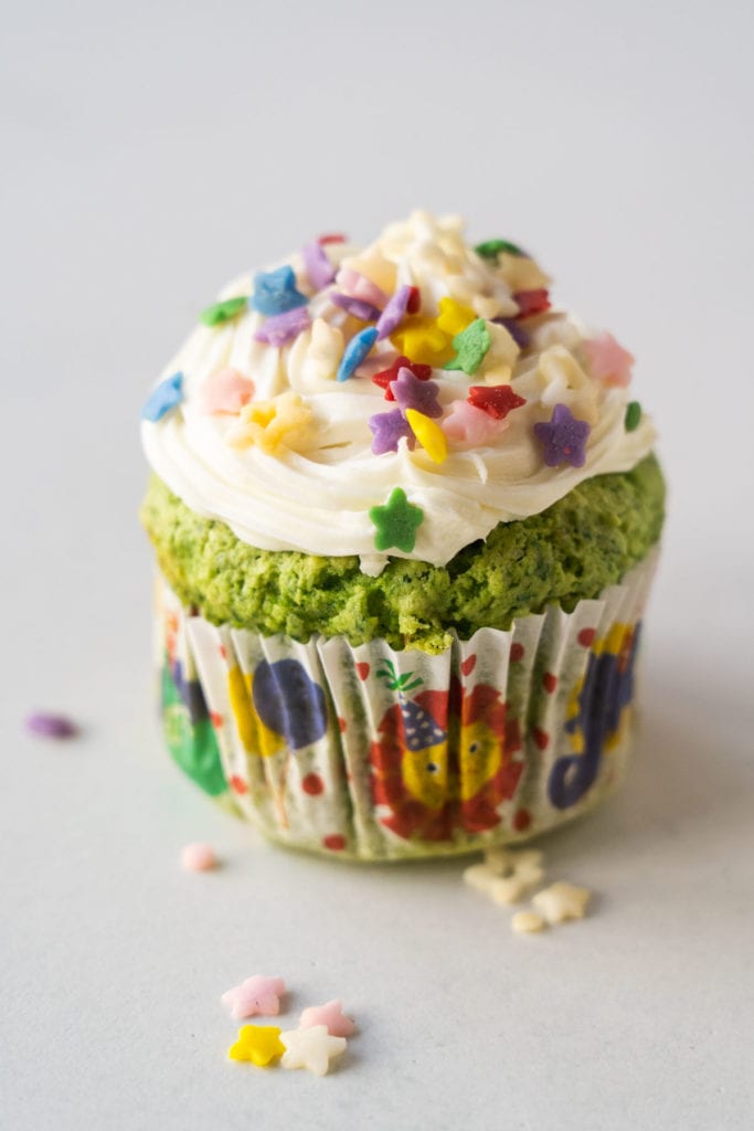 Green cupcakes with sprinkles on top.