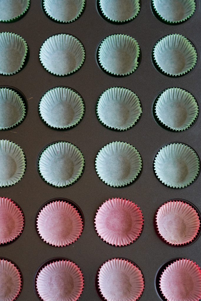 muffin pan filled with red and green liners.