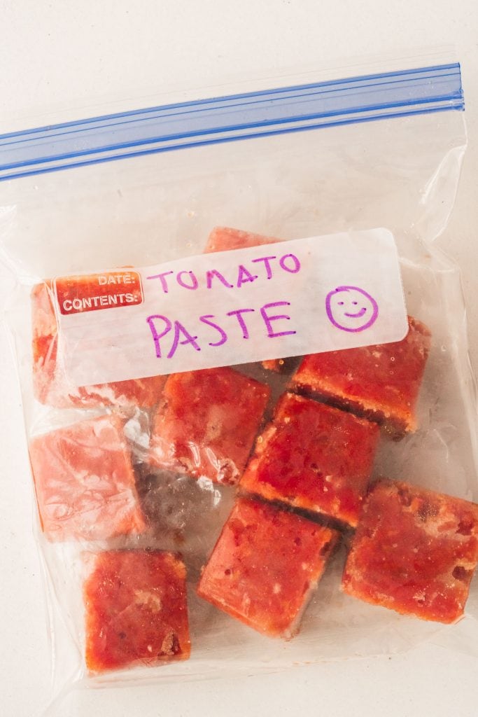 cubes of froze tomato patse in freezer bag.