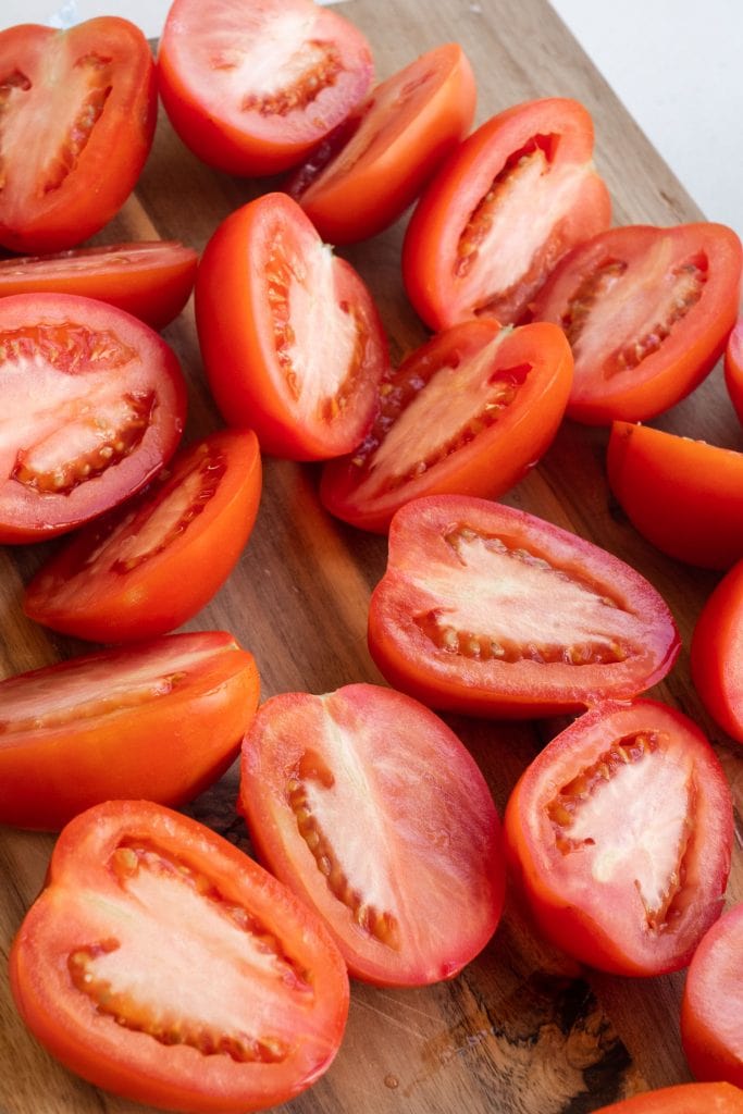 tomatoes cut in half on cutting board