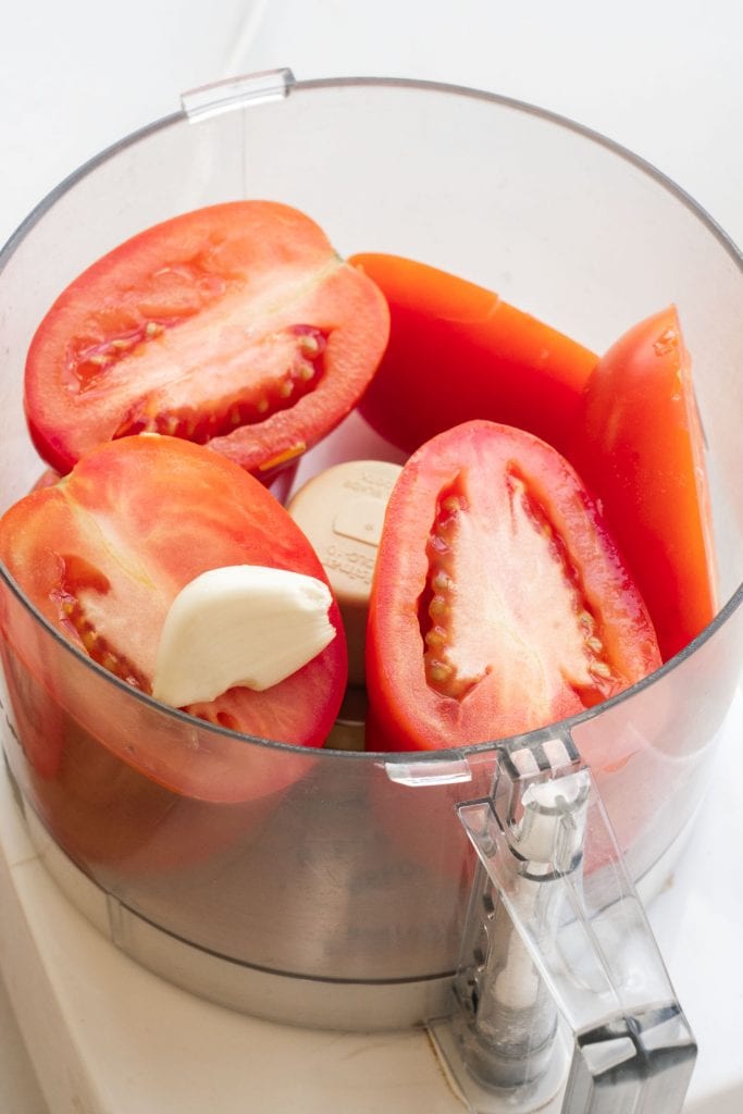 tomatoes and garlic in food processor bowl. 