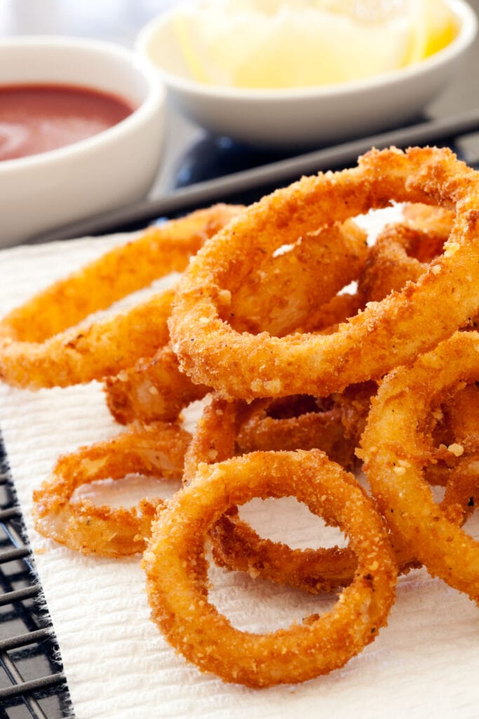 onion rings next to dips on table.