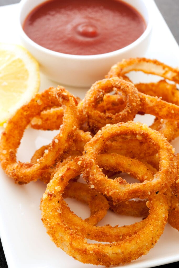 onion rings on table with bowl of ketchup