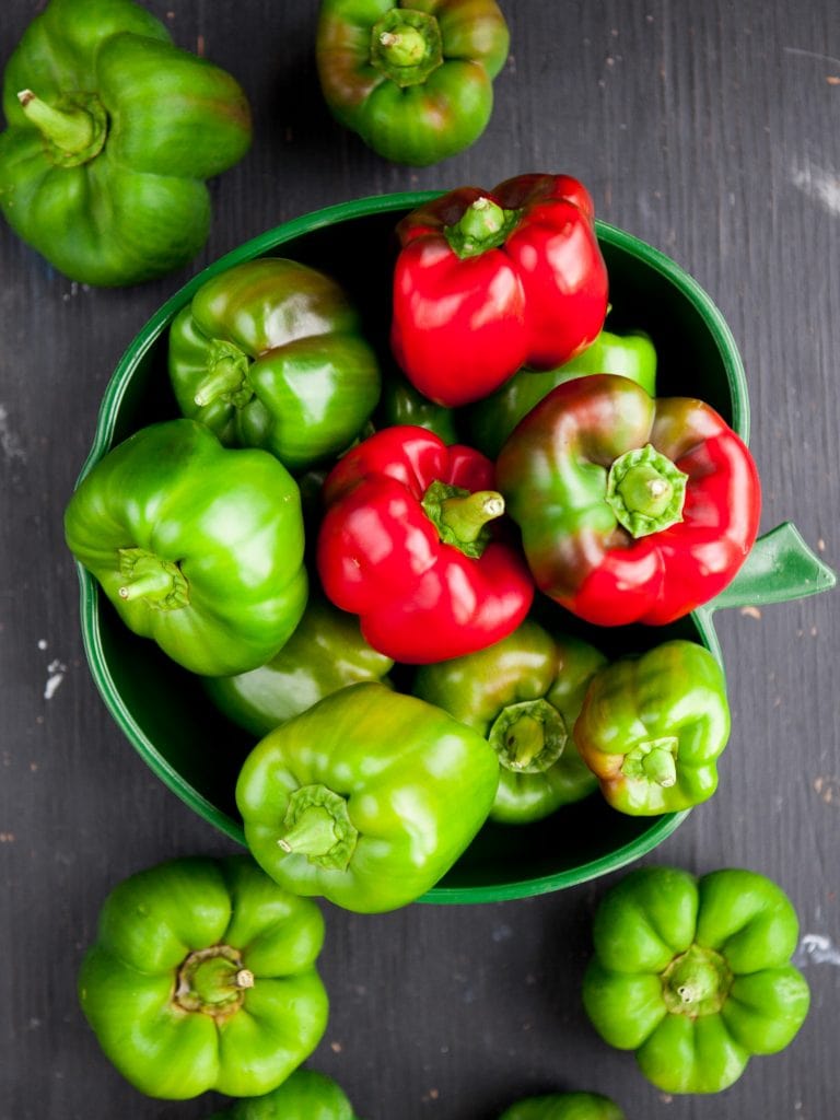 fresh green peppers in dish on table.