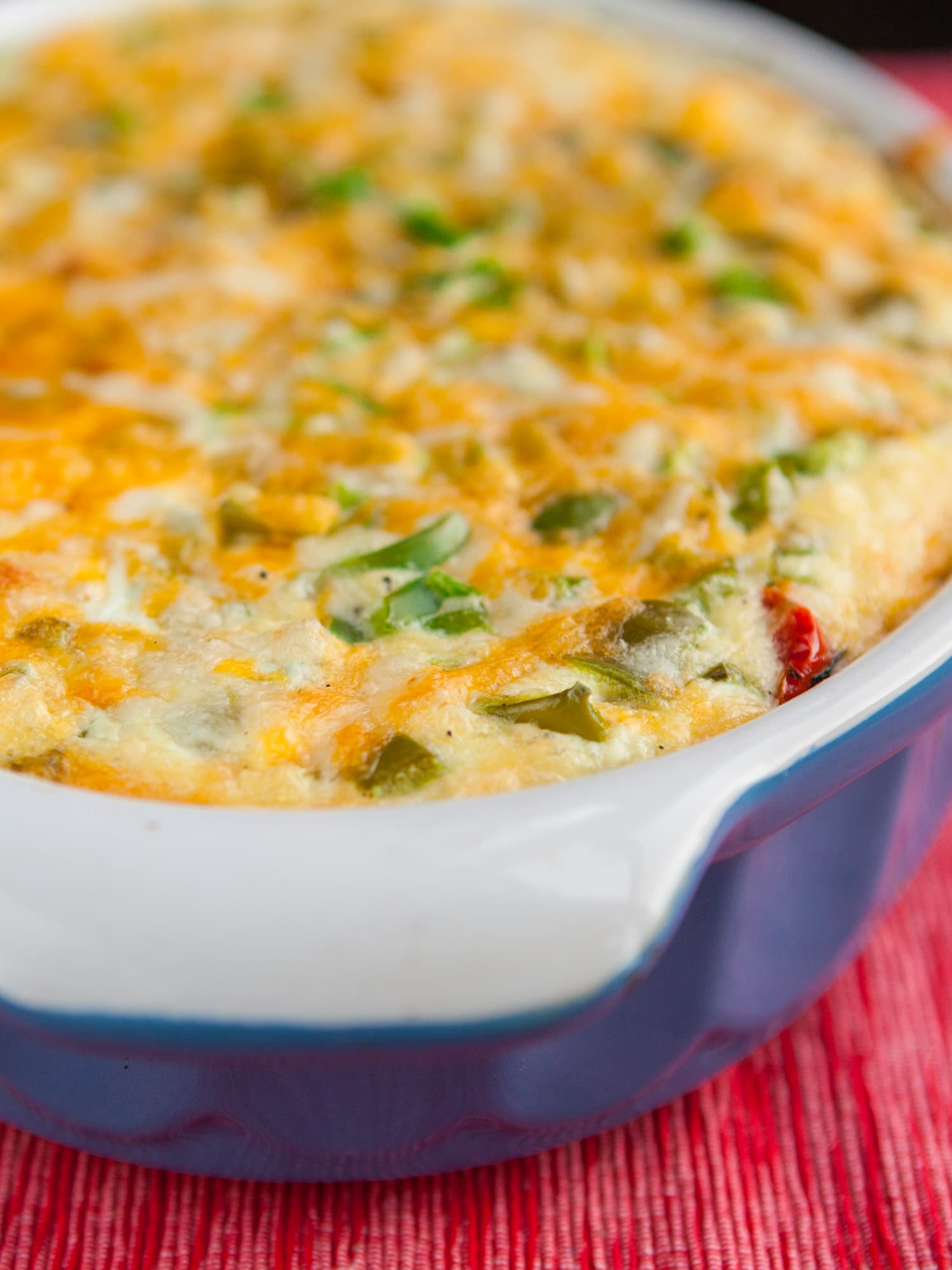 baked cheesy green pepper casserole in blue baking dish on table.