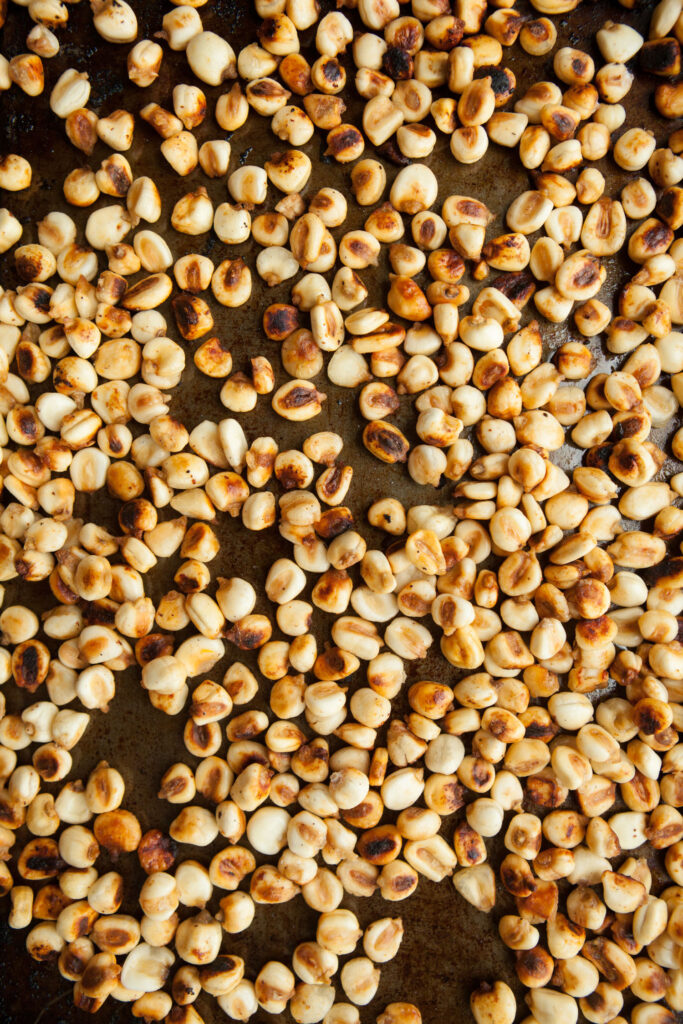 closeup of roasted corn nuts on baking sheet.