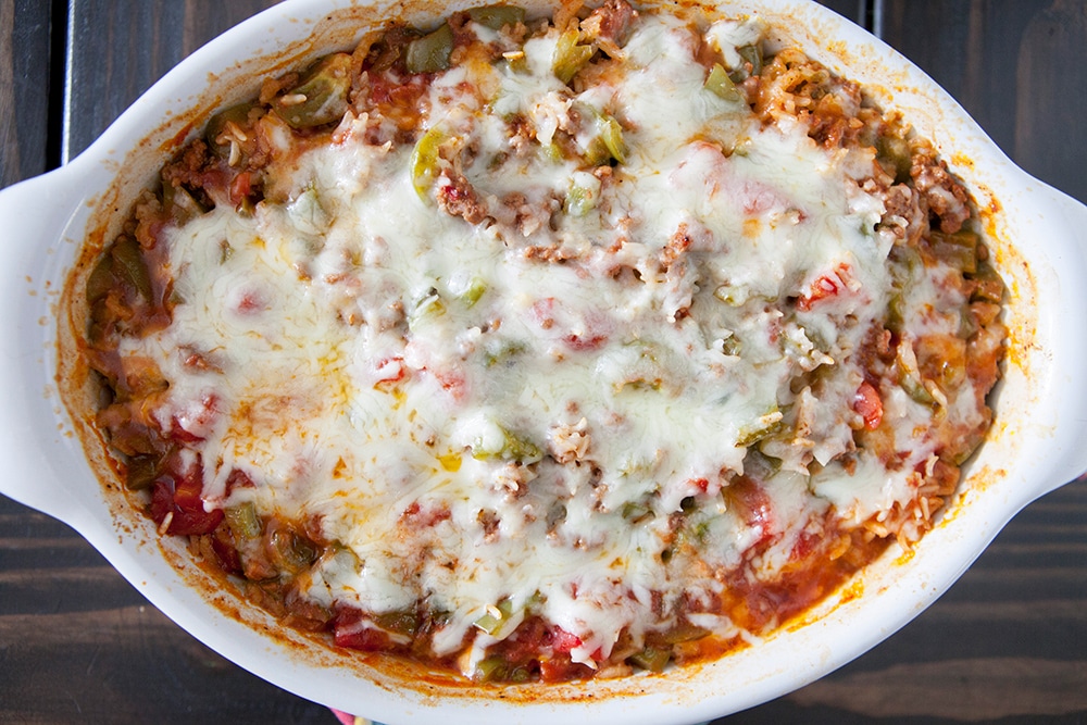 EASY Stuffed Pepper Casserole is baked in the oven for a cheesy dinner meal! This dish uses my Mother's famous stuffed pepper recipe but I turned it into a casserole to make it quicker. It's filled with ground beef, green peppers, diced tomatoes, rice and smothered in mozzarella cheese.