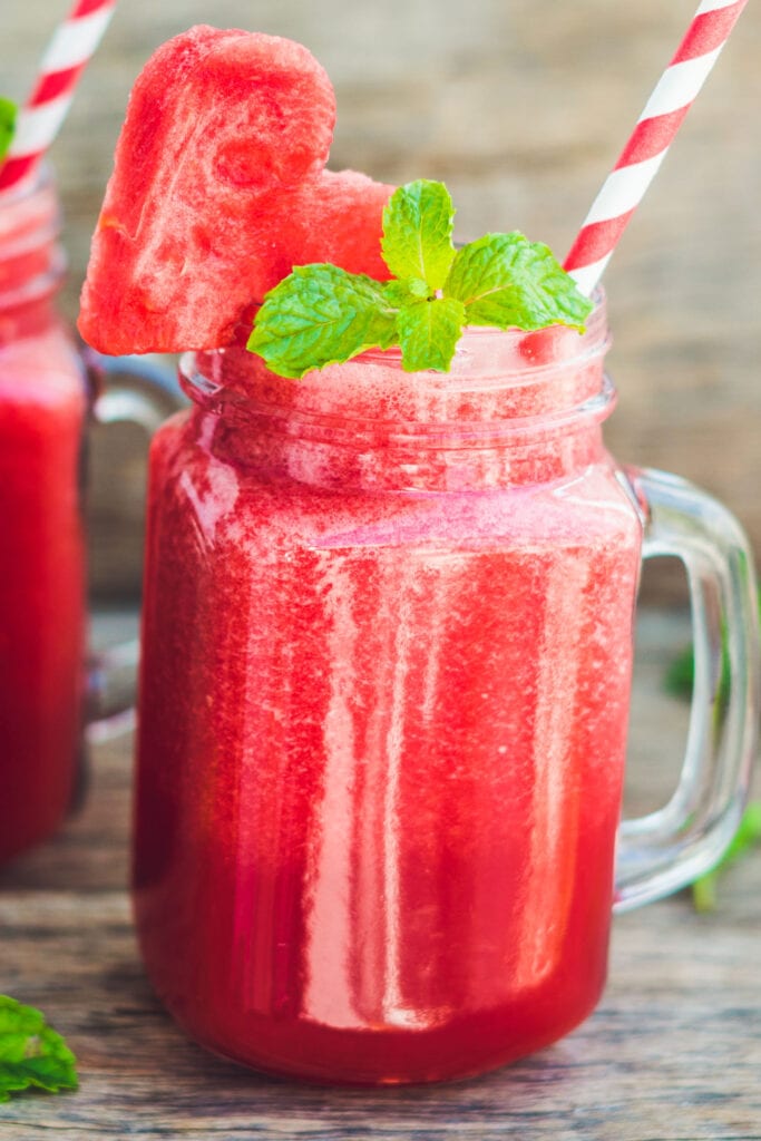 watermelon smoothie in mason jar with fresh mint on top.