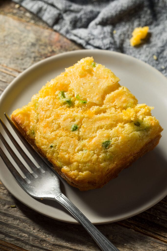 slice of cornbread on plate with fork.