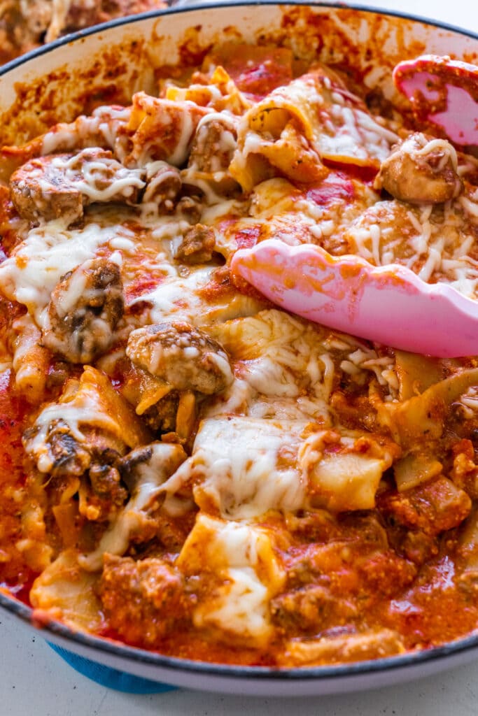 lasagna in skillet with cheese and sauce on it.