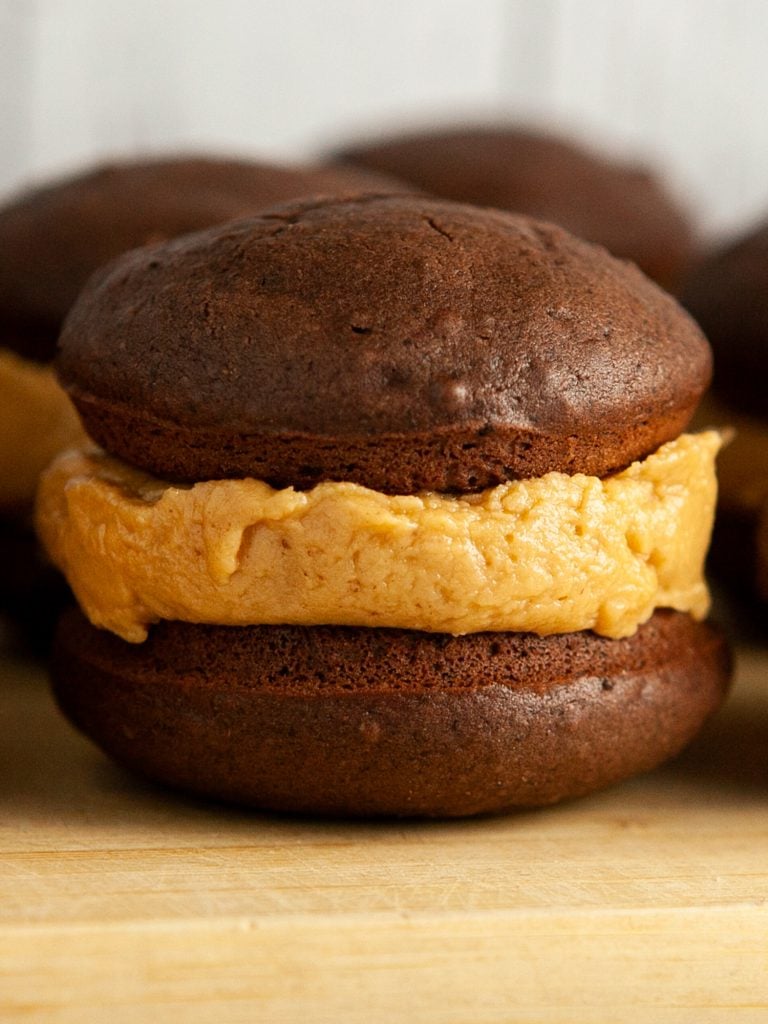 closeup of chocolate whoopie pie with peanut butter frosting in it.