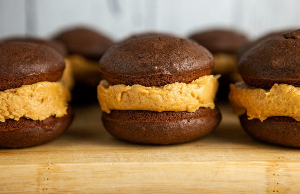 horizontal image of chocolate whoopie pies on cutting board.