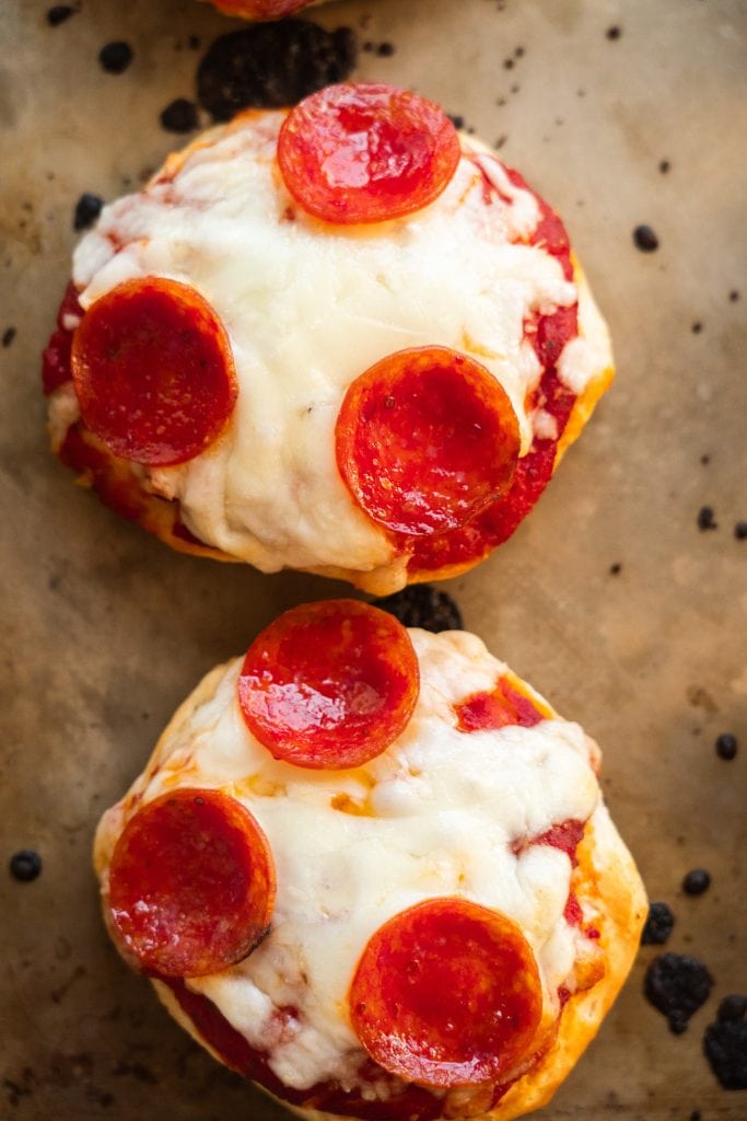 baked mini pizzas on baking sheet.