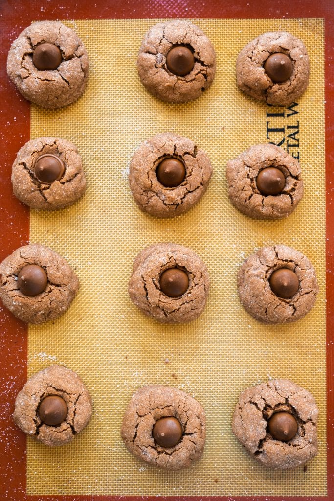 peanut butter blossoms on silicone bake mat on cookie sheet.