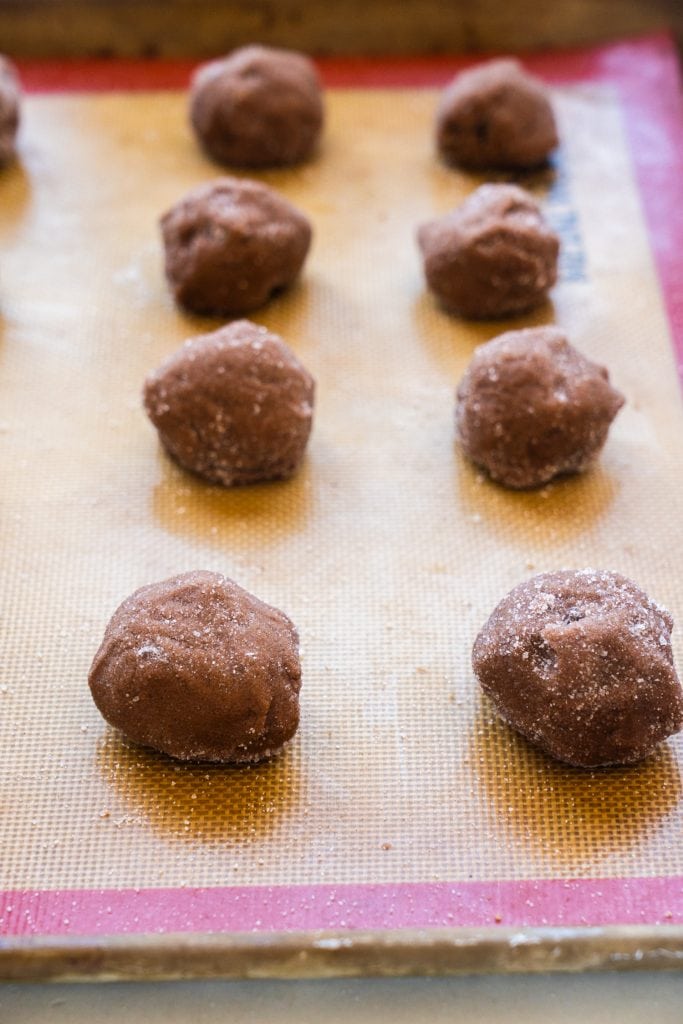 cookie balls rolled in sugar on cookie sheet.