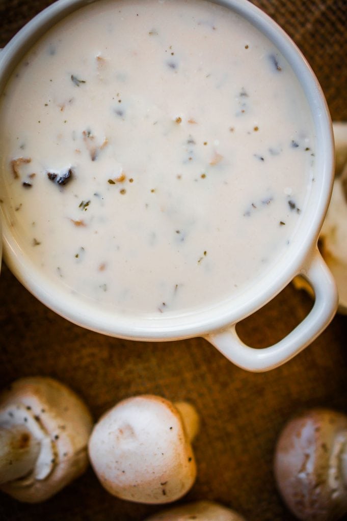 homemade cream of mushroom soup in white bowl on table.