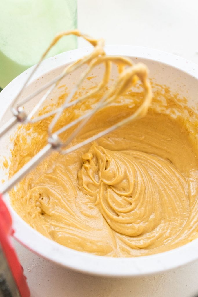 donut batter in bowl with electric hand mixer next to it.