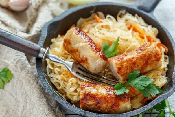 Slow Cooker Sausage and Sauerkraut recipe served over mashed potatoes! This easy crockpot meal will become your family's new favorite dinner! Use a good pork kielbasa for full flavor! It's inspired by my Polish family!