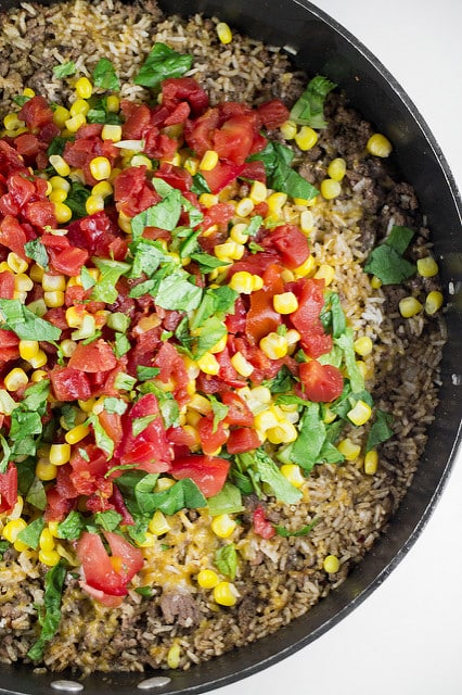 Easy to make One Pan Taco Casserole recipe! Ingredients include lettuces, tomatoes, corn, instant rice and shredded cheese.