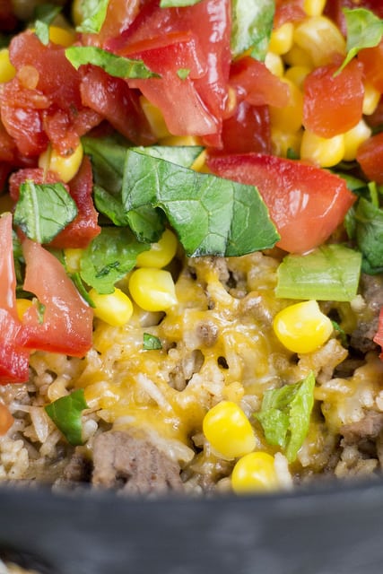 Easy to make One Pan Taco Casserole recipe! Ingredients include lettuces, tomatoes, corn, instant rice and shredded cheese.