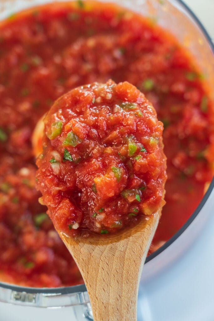 spoon lifting salsa out of food processor.