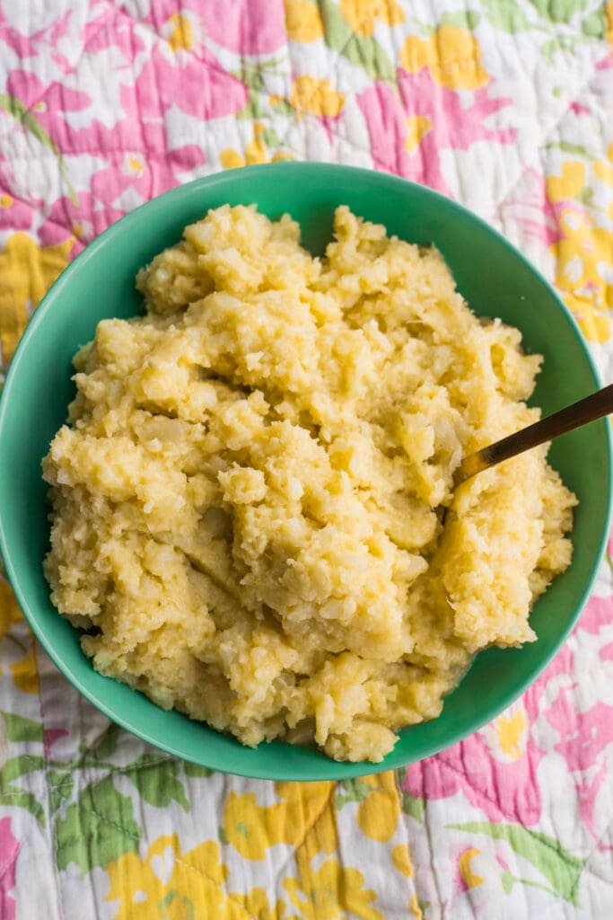 bowl of mashed cauliflower with spoon in it. 