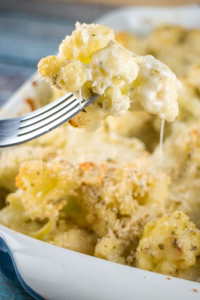 fork holding up cheesy cauliflower