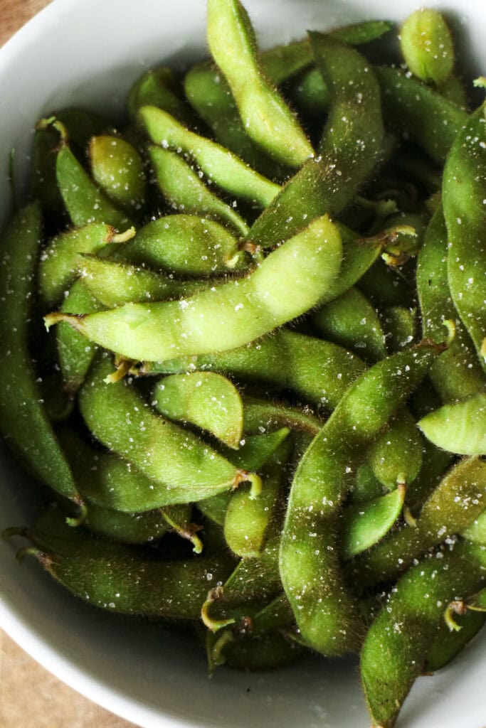 closeup shot of salted edamame in bowl. 