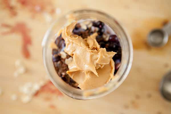 Overnight Blueberry Peanut Butter Oatmeal is a breakfast that's ready for you in the morning. This recipe uses old fashioned oats, creamy peanut butter, flax seeds, maple syrup and blueberries to make it one delicious quick breakfast.