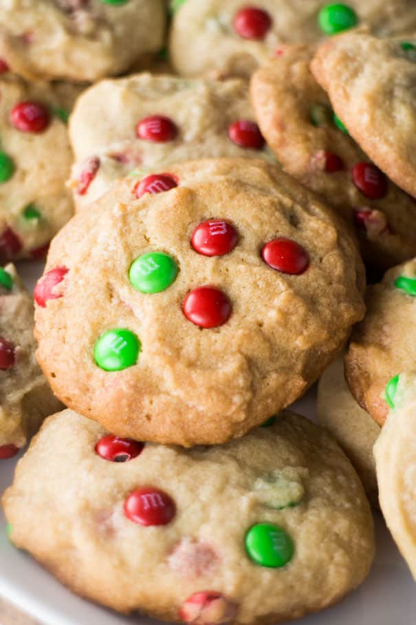 These M&M Christmas Cookies are made with a simple, delicious sugar cookie dough and plenty of chocolate candy pieces. A fun and festive treat for cookie exchanges and gift giving that can easily be customized to suit your occasion!