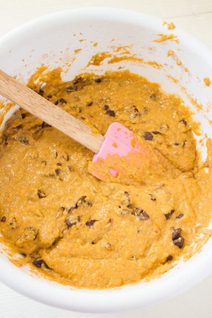 carrot bread batter with chocolate chips in bowl with pink spatula. 