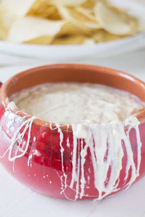 SLOW COOKER Creamy Onion Dip is so creamy and easy to make. Caramelized onions are mixed with sour cream and mozzarella cheese to make a extra creamy homemade dip! This simple recipe is best served hot with potato chips - perfect for a party dip! 
