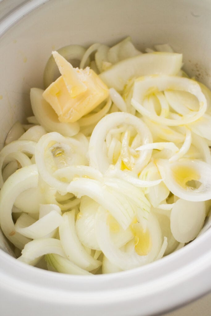 onions and butter in slow cooker.