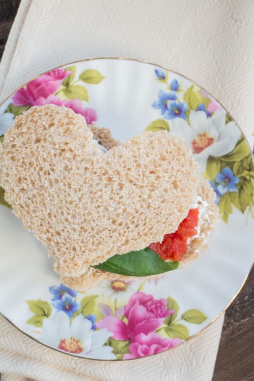 EASY Ricotta and Tomato Tea Sandwiches made with tomatoes and an easy homemade ricotta garlic mixture that tastes amazing! Use cookie cutters to cut out hearts in your bread – perfect for an afternoon tea party, baby shower or for Valentine's Day. 