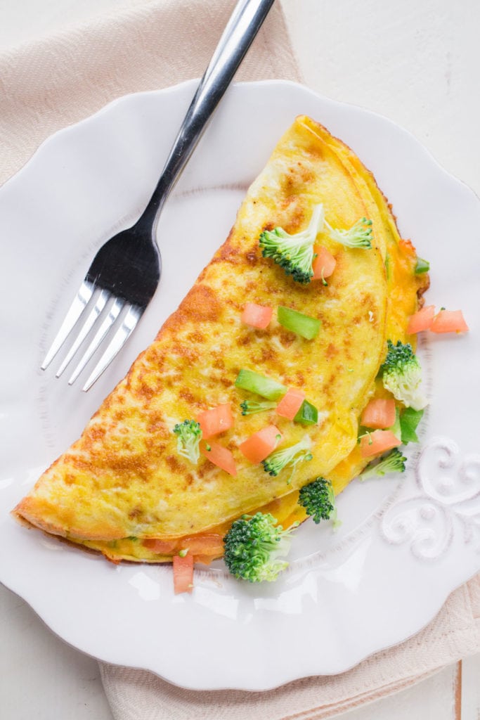Cheesy Vegetable Omelette is packed with garden fresh vegetables!   This healthy breakfast recipe is easy to make and shows you how to make a perfect omelette step by step! 