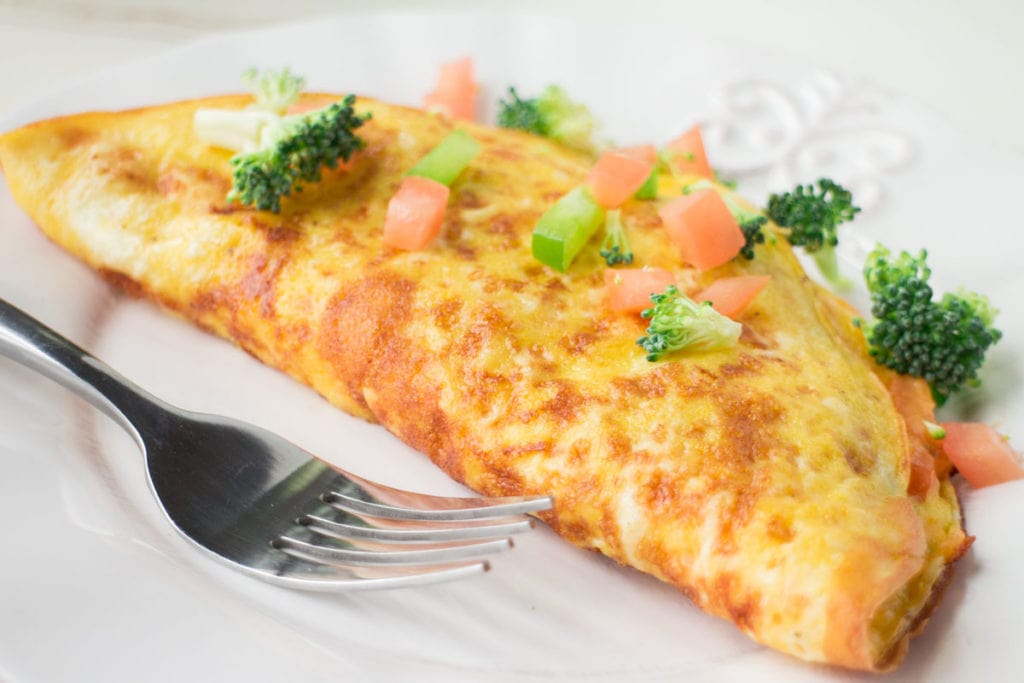Cheesy Vegetable Omelette is packed with garden fresh vegetables!   This healthy breakfast recipe is easy to make and shows you how to make a perfect omelette step by step! 