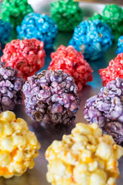 How to Make Rainbow Popcorn Balls with marshmallow! This easy DIY recipe walks you through how to make colored popcorn balls using food dye and karo syrup! They're a great snack and dessert for birthday parties!