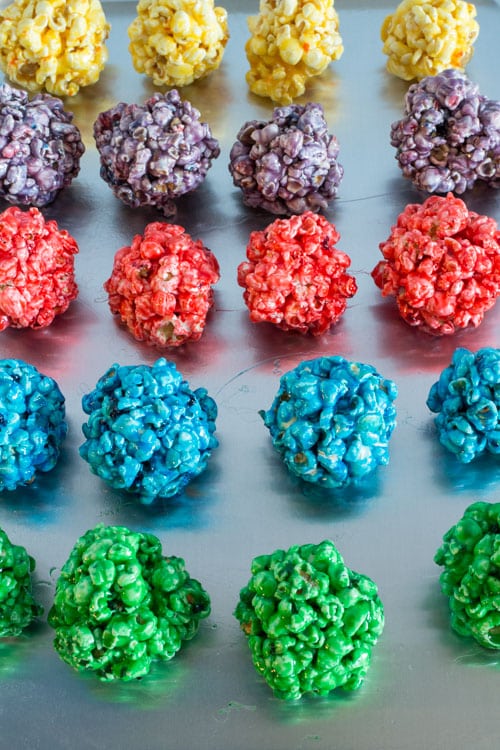 How to Make Popcorn Balls with marshmallow! This easy DIY recipe walks you through how to make colored popcorn balls using food dye and karo syrup! They're a great snack and dessert for birthday parties!