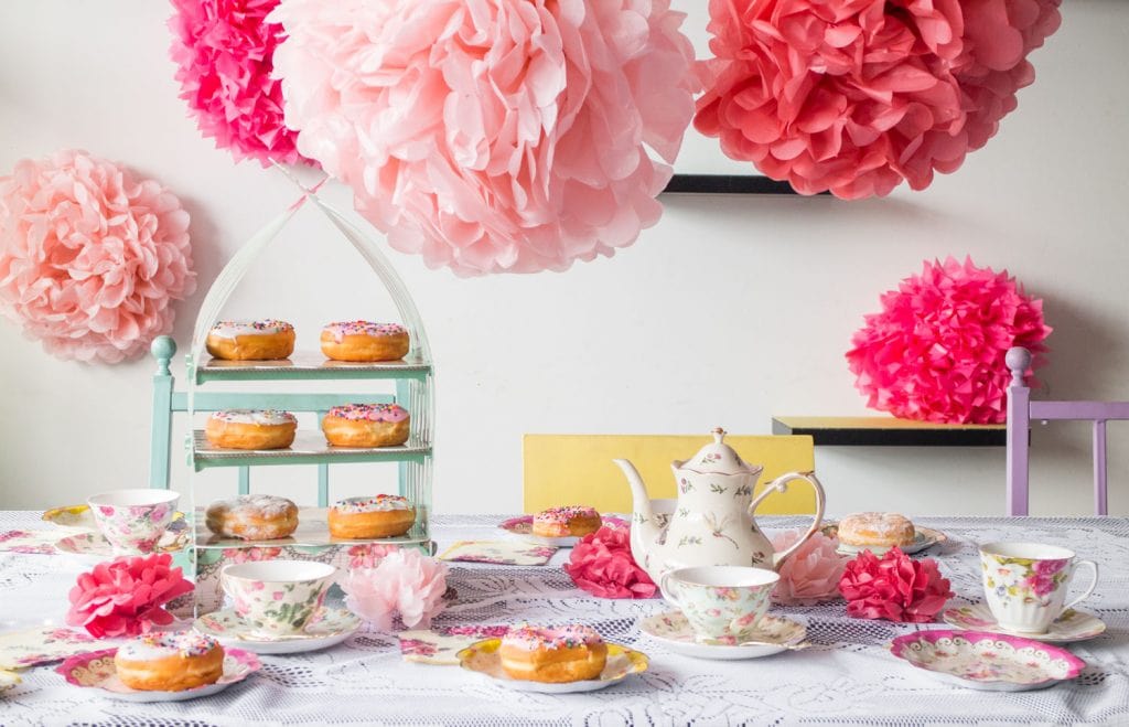 tea party set up on table with food and tea kettle, tea cups