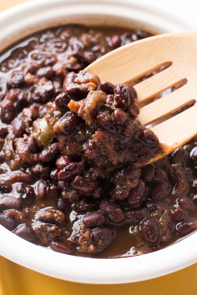 bowl of slow cooker black beans with spoon in it.