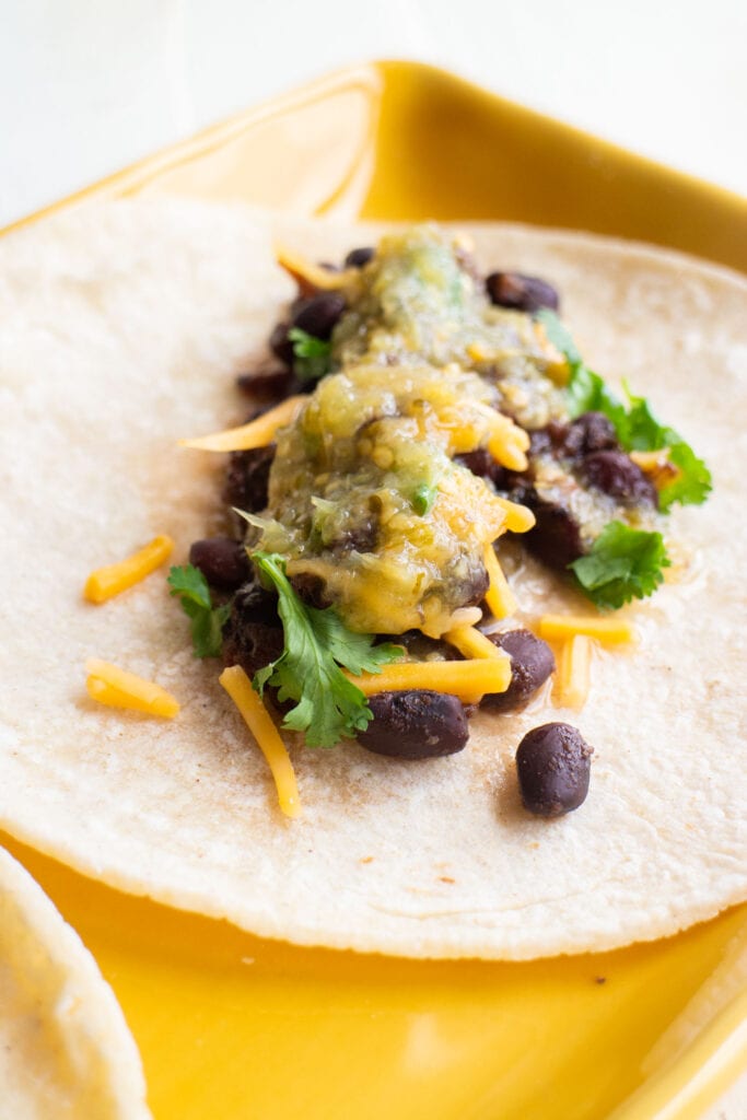 black beans on tortilla with cheese and salsa.