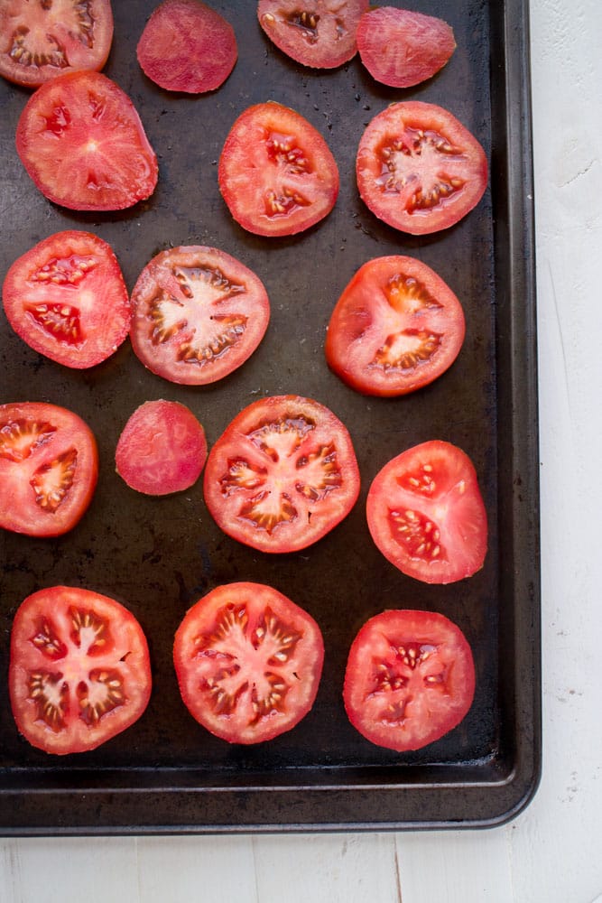 HEALTHY, SIMPLE Roasted Tomato Salad recipe that is a perfect way to enjoy fresh Summer tomatoes! Fresh tomatoes are roasted with olive oil for 25 minutes to create a delicious salad! You can use any type of tomatoes - including cherry and heirloom! 
