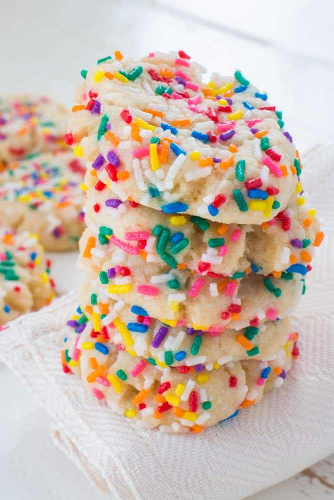 RAINBOW Sprinkled Butter Cookies! These delicious cookies are easy to make and uses evaporated milk to make the cookies extra soft! They melt in your mouth!  Roll them around in colored sprinkles to make them more fun! Recipe makes 2 dozen cookies.