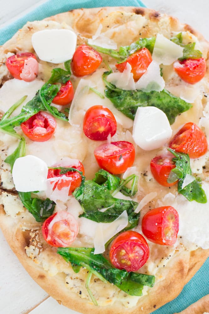 Delicious Truffled Three Cheese Flatbread with grape tomatoes and arugula! Ready in under 15 minutes! Only 650 calories per serving!