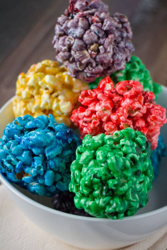 How to Make Rainbow Popcorn Balls with marshmallow! This easy DIY recipe walks you through how to make colored popcorn balls using food dye and karo syrup! They're a great snack and dessert for birthday parties!